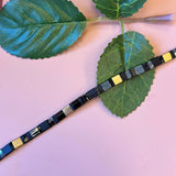 FRIIHOF+SIIG SORT/GULD PERLEARMBÅND MED FIREKANTET GLASPERLE OG GULD LÅS
Fint perlearmbånd med firekantet glasperler i farverne mat sort, guld, og skinne sort fra Friihof+Siig. Perlerne sidder på en wire snor og har en guld lås.
Wire snor
Små perler
Måler ca. 17,5 cm.
Forlænger måler ca. 1,5 cm.
Materiale: Messing og forgyldt med 16 karat guld.