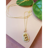 Guldbelagt halskæde med emblem der forestiller en budda den har små sten hele vejen rundt set liggende tæt på emblem