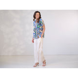 Blå bluse med læg ved bryst og v udskæring samt korte ærmer og flæser i halsen set fra siden på prepair model