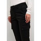 Sorte bukser med fast linning og lommer i siden set tæt på lommer i siden