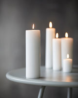 Flere bloklys i forskellige størrelser på et lille bord.