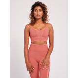 Rosa sportstop fra Hummel med smalle regulerbare stropper som går ned i på ryggen i en klassisk bryderyg den har lavet i et strækbart og sømløst materiale set forfra på Hummel model