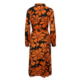 Skøn gennemknappet lang kjole med bindebånd i taljen og det fineste orange blomsterprint bundfarven er sort også har den lange ærmer set bagfra