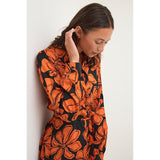 Skøn gennemknappet lang kjole med bindebånd i taljen og det fineste orange blomsterprint bundfarven er sort også har den lange ærmer set tæt på kaffe model