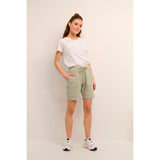 Lækre bløde shorts fra Kaffe i en flot støvet grøn farve de har elastikkant ribkanter bindebånd og dybe lommer i siden set forfra på Kaffe model