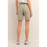Lækre bløde shorts fra Kaffe i en flot støvet grøn farve de har elastikkant ribkanter bindebånd og dybe lommer i siden set bagfra på Kaffe model