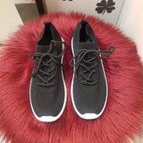 sorte sneakers med sorte snøre og hvide såler set oppe fra