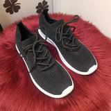 sorte sneakers med sorte snøre og hvide såler set fra forfra