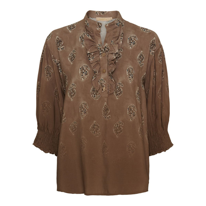 6317 MARTA DU CHÀTEAU UNNUR BLOUSE FANGO FADED  Paisley print bluse fra Marta du cháteau. Blusen er med en sød flæsekant og en lille v-udskæring ved brystet. Blusen har 3 knapper, så man kan få en lidt større v-udskæring. Blusen har 3/4 ærmer med smock for enden. Blusens print er i farverne, brun, blå, beige mm og har en løs pasform.&nbsp;  Flæsekant med lille V-udskæring Paisley print 3/4 ærmer og smock for enden Løs Pasform&nbsp;