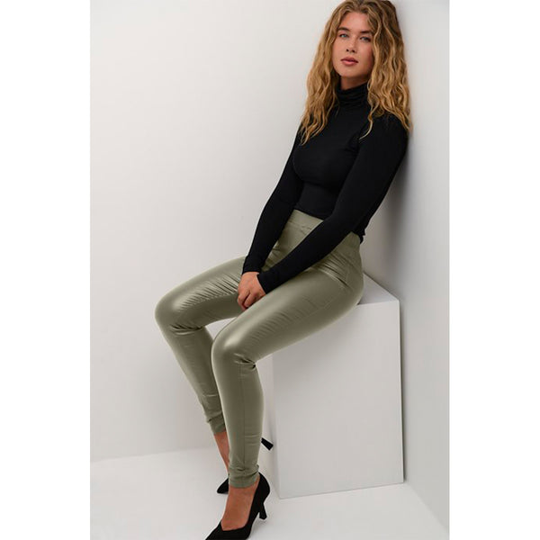 Grønne læderlook leggings med elastik i livet og smalle ben set fra siden på model