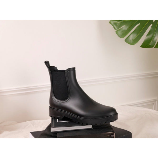 Sorte ankel støvler med elastik i et gummistøvle ligende materiale set fra siden