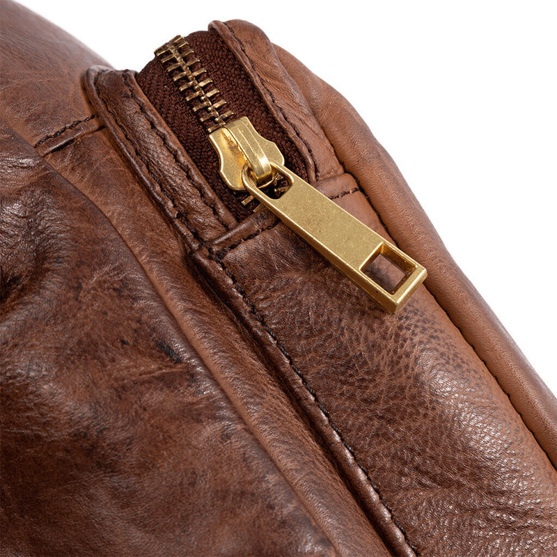 Cognac farvet læder taske med et stort og mindre rum den har justerbar rem set på lynlås