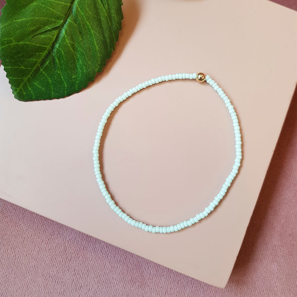 mint grønt elastik perle armbånd med guld perle set oppefra