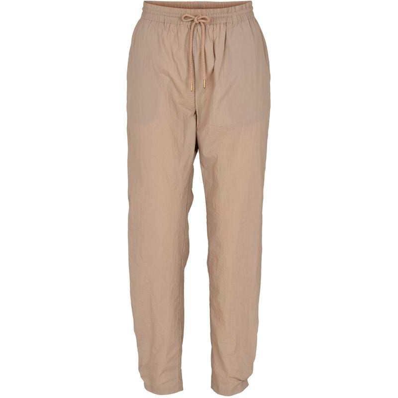Sandfarvede bukser med elastik og snøre i taljen og lommer i siden set forfra