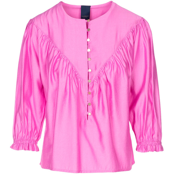 Pink bluse med flade knapper ned fortil den har tre kvart ærmer med elastik set forfra