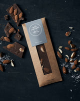 Milk chocolate salt caramel på bord med enkelte stykker knækket ud på bordet