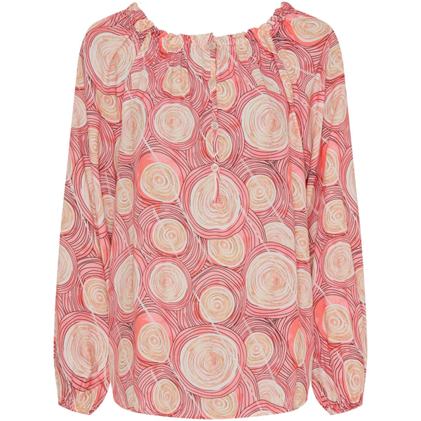 Klassisk rosa bluse med et fint print den har bådudskæring med elastik og stolpe ned fortil med små knapper den har lange  ærmer som afsluttes med elastik set forfra 