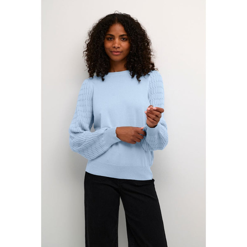 NANNA PULLOVER CELESTIAL BLUE  Lækker elastisk strikket pullover fra Kaffe. Nanna pullover har rund hals, lange ærmer med strikket mønster og rib kanter ved hals, ved ærme afslutning og i bunden. Den er perfekt til et par jeans eller indenunder et jakkesæt.   Elastisk Rund hals, lange ærmer og rib kanter Strikket mønster Fin lyse blå farve  Normal kropsnær pasform