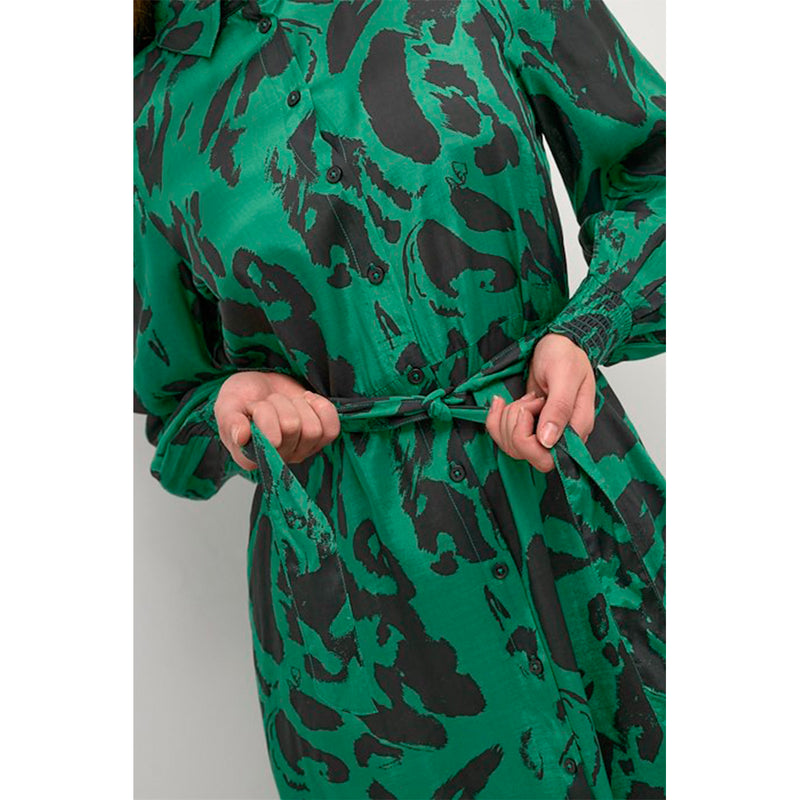Lang grøn og gennemknappet kjole med bindebånd og lange ærmer som afslutte med smock den har almindelig skjortekrave set tæt på bindebånd