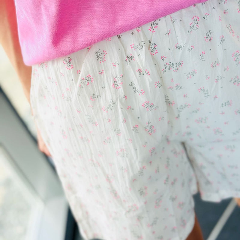 SARA SHORTS CREME PINK FLOWER  Fine shorts fra Liberté med elastisk talje og skrå lomme i begge sider. Disse shorts kommer i en dejlig let bomuldskvalitet med løs pasform og det fineste creme farvet bundfarve med pink blomsterprint.  Elastik i livet og skrålommer Super blød og behagelig Pink blomsterprint Normal løs pasform