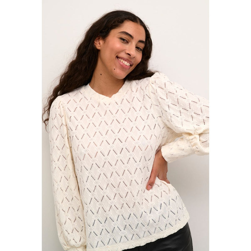 TINE LACE BLOUSE CHALK  Flot tætsiddende blondebluse fra Kaffe i en råhvid farve, Blonderne er i det fineste blomster mønster, der giver den et smukt og eksklusivt look. Den har rund hals og lange ærmer med et lille puf på skulderen.&nbsp;   Rund hals, lange ærmer med et lille puf, blonde og let gennemsigtig Mønster blomsterprint Farven er råhvid Tætsiddende pasform