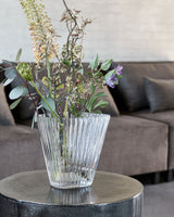 Glasvasen set med blomster på lille bord