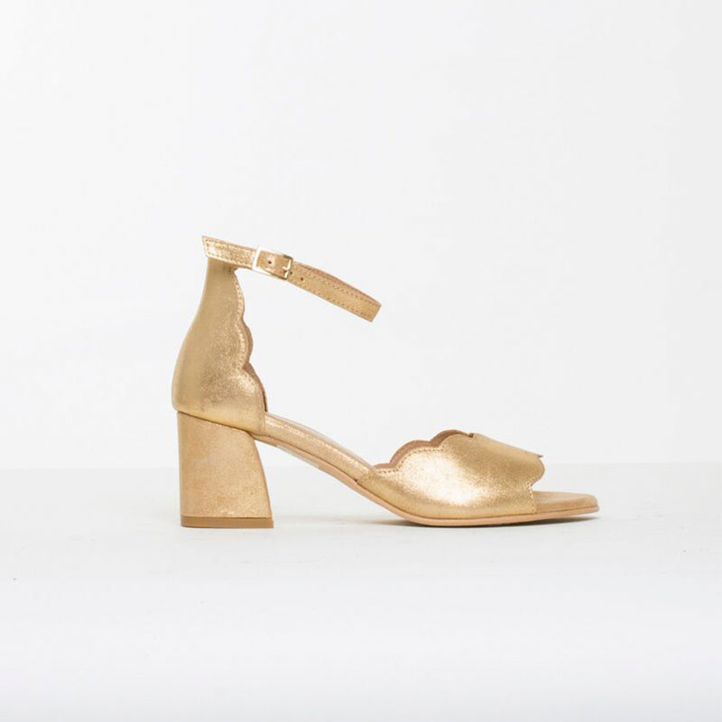 Guld sandal med bølget rem og tyk hæl set fra siden 