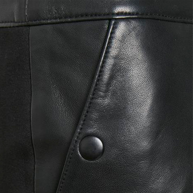 sort nederdel i skind med lomme og en knap samt syninger og stof set tæt på