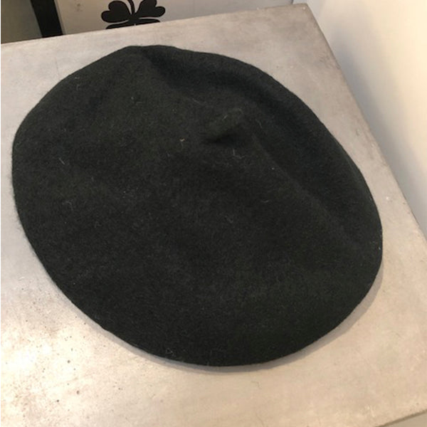 sort fransk hat med dut i toppen i set oppe fra