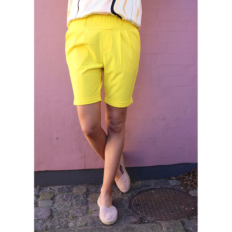 Model i Habit shorts i stærk gul med elastik i livet