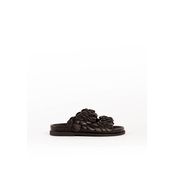 Sort sandal fra Bukela med 2 remme overdækket med sorte blomster det er en flad sandal set fra siden