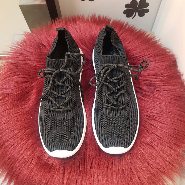 sorte sneakers med sorte snøre og hvide såler set oppe fra